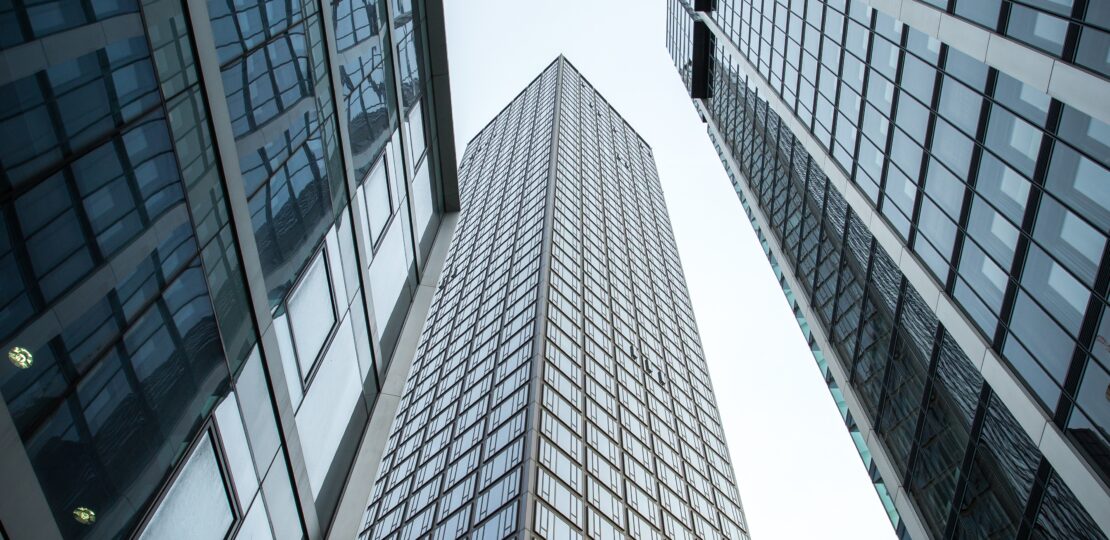 Vertical low angle shot of high rise skyscrapers in a glass facade in Frankfurt, Germany
